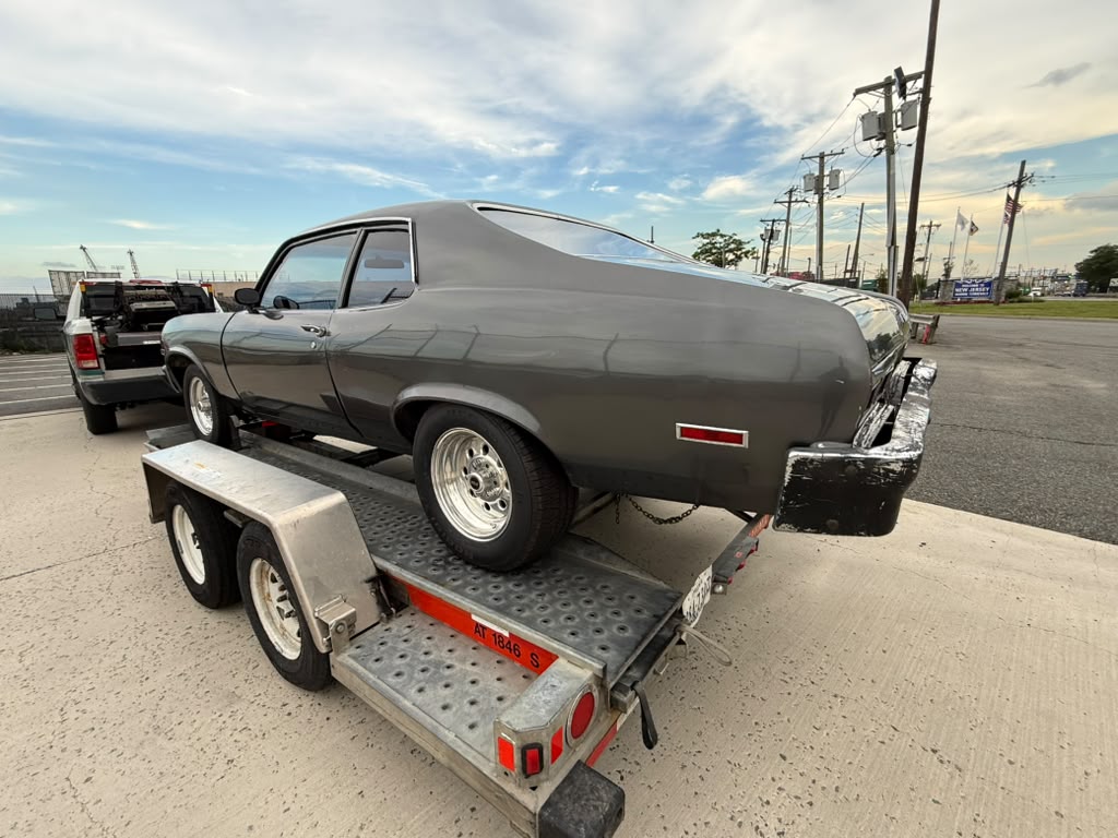 Chevrolet Nova 1973 zijaanzicht op een U-Haul-aanhanger bij de containerhaven in New Jersey